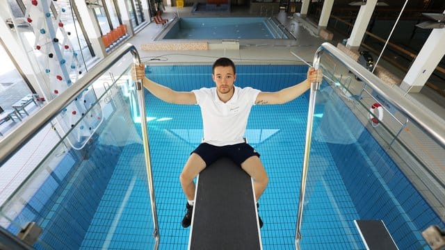 Der Schwimmmeister Thomas Dyck sitzt im leeren Zollstockbad in Köln auf einem Sprungbrett. Der Schwimmmeister Thomas Dyck sitzt im leeren Zollstockbad in Köln auf einem Sprungbrett.