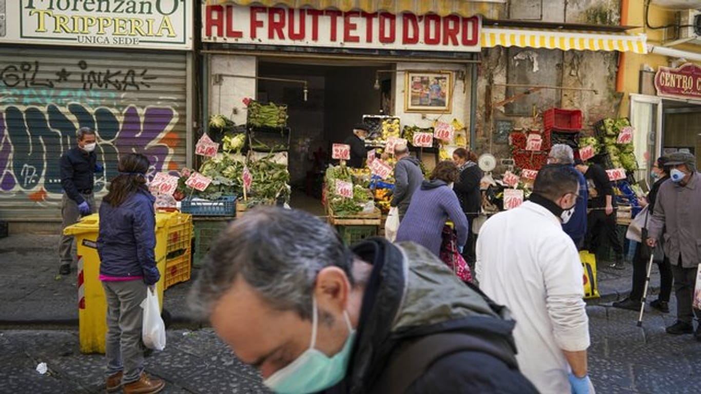 Kunden mit Mundschutz kaufen in einem Geschäft in Neapel Obst und Gemüse.