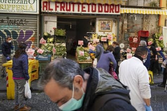 Kunden mit Mundschutz kaufen in einem Geschäft in Neapel Obst und Gemüse.