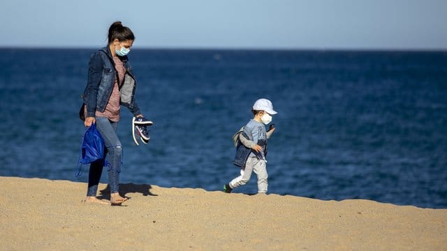Eine Frau und ihr Sohn an einem Strand in der Nähe von Barcelona in Spanien. Eine Frau und ihr Sohn an einem Strand in der Nähe von Barcelona in Spanien.