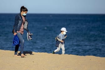 Eine Frau und ihr Sohn an einem Strand in der Nähe von Barcelona in Spanien.