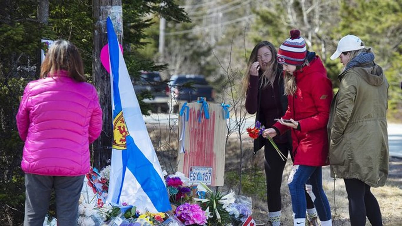 Frauen legen Blumen an einer Gedenkstätte für die Opfer des Amoklaufs in Nova Scotia ab.
