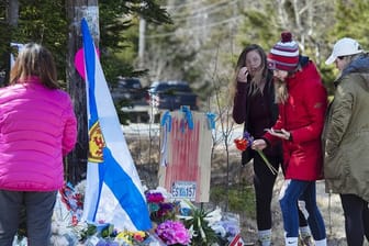Frauen legen Blumen an einer Gedenkstätte für die Opfer des Amoklaufs in Nova Scotia ab.
