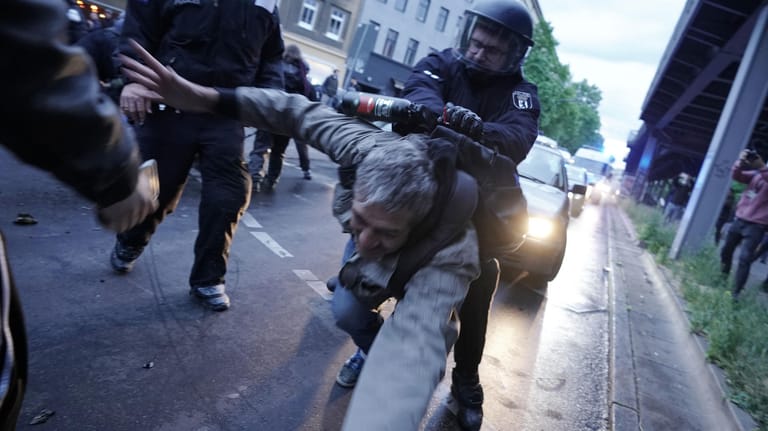 Ein Polizist geht gegen einen Demonstranten vor: In Berlin haben trotz Corona-Krise viele Menschen am 1. Mai demonstriert.