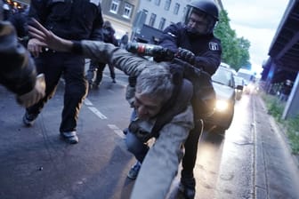 Ein Polizist geht gegen einen Demonstranten vor: In Berlin haben trotz Corona-Krise viele Menschen am 1. Mai demonstriert.