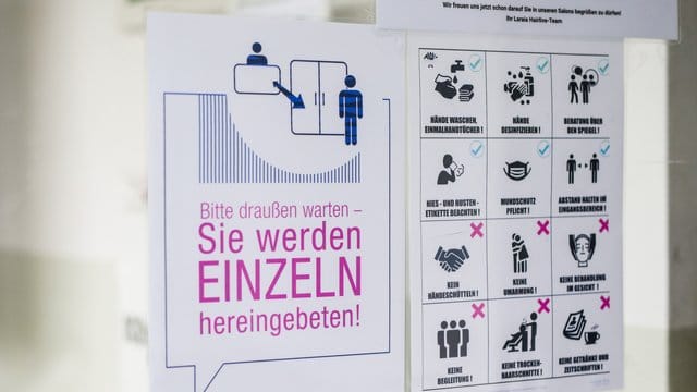 Verhaltensvorgaben weisen Kunden in einem Friseursalon über die neu geltenden Regeln im Salon hin. Verhaltensvorgaben weisen Kunden in einem Friseursalon über die neu geltenden Regeln im Salon hin.
