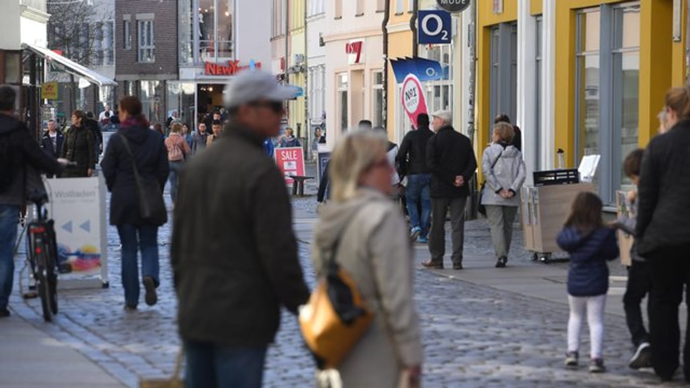 Menschen in einer Einkaufstraße im Zentrum von Stralsund in Mecklenburg-Vorpommern.