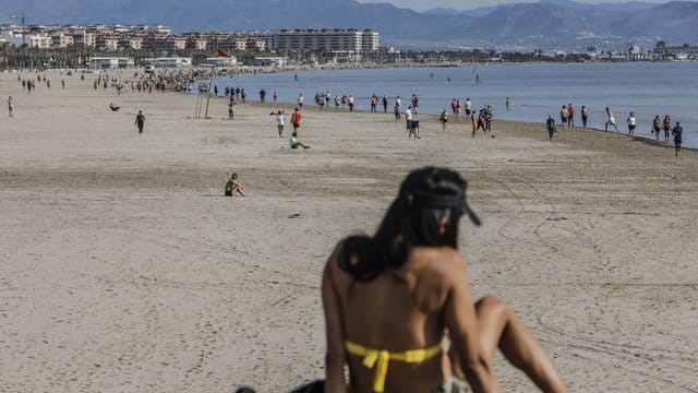 Eine Frau genießt ein Sonnenbad am Strand von Malvarrosa in Valenica. Eine Frau genießt ein Sonnenbad am Strand von Malvarrosa in Valenica.