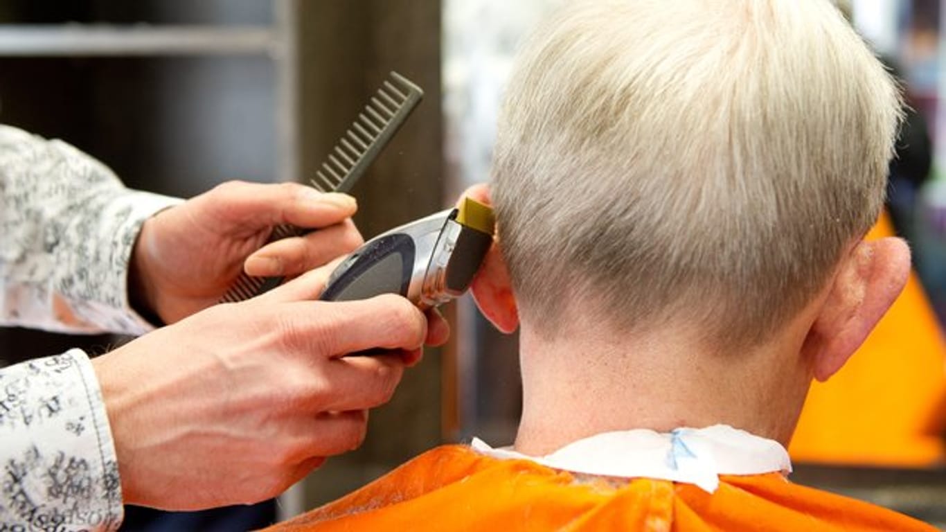 Ein Friseur schneidet einem Kunden die Haare