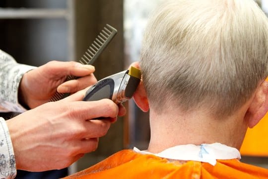 Ein Friseur schneidet einem Kunden die Haare