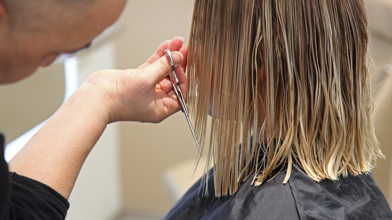 Ein Friseur beim Haareschneiden: Berliner Salons mussten wegen Corona eine Zwangspause einlegen.