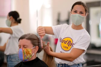 Eine Friseurin kämmt einer Kundin die Haare (Symbolbild): In Rheinland-Pfalz dürfen Friseursalons wieder öffnen.