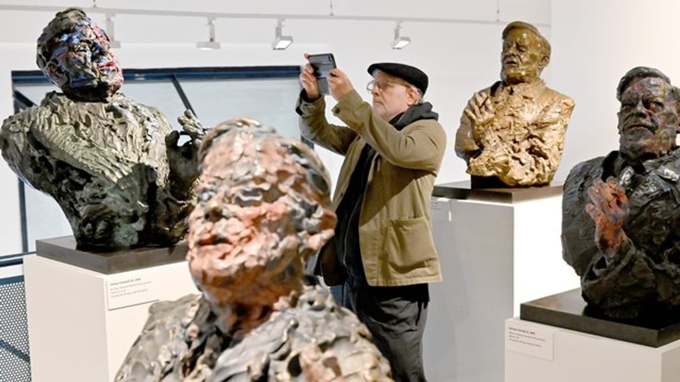 Der Künstler Rainer Fetting zwischen Helmut-Schmidt-Skulpturen.