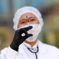 Impfstoff im Blick: Eine Virologin posiert mit einer Spritze zur Impfung gegen das Corona-Virus (Symbolfoto). Es gibt noch kein Mittel, aber schon Debatten. Ein Gesetzentwurf hat zwischenzeitlich die Furcht vor einem Impfzwang wachsen lassen.