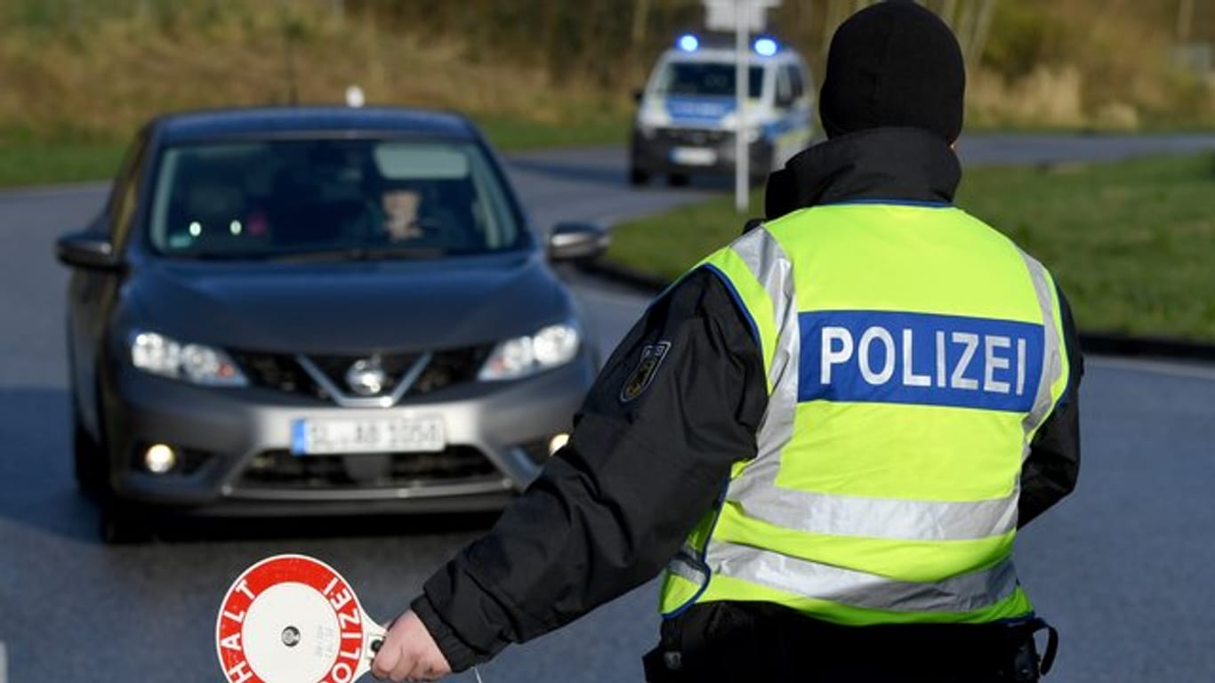 Ein Beamter der Bundespolizei steht an der deutsch-dänischen Grenze an einem Kontrollpunkt.