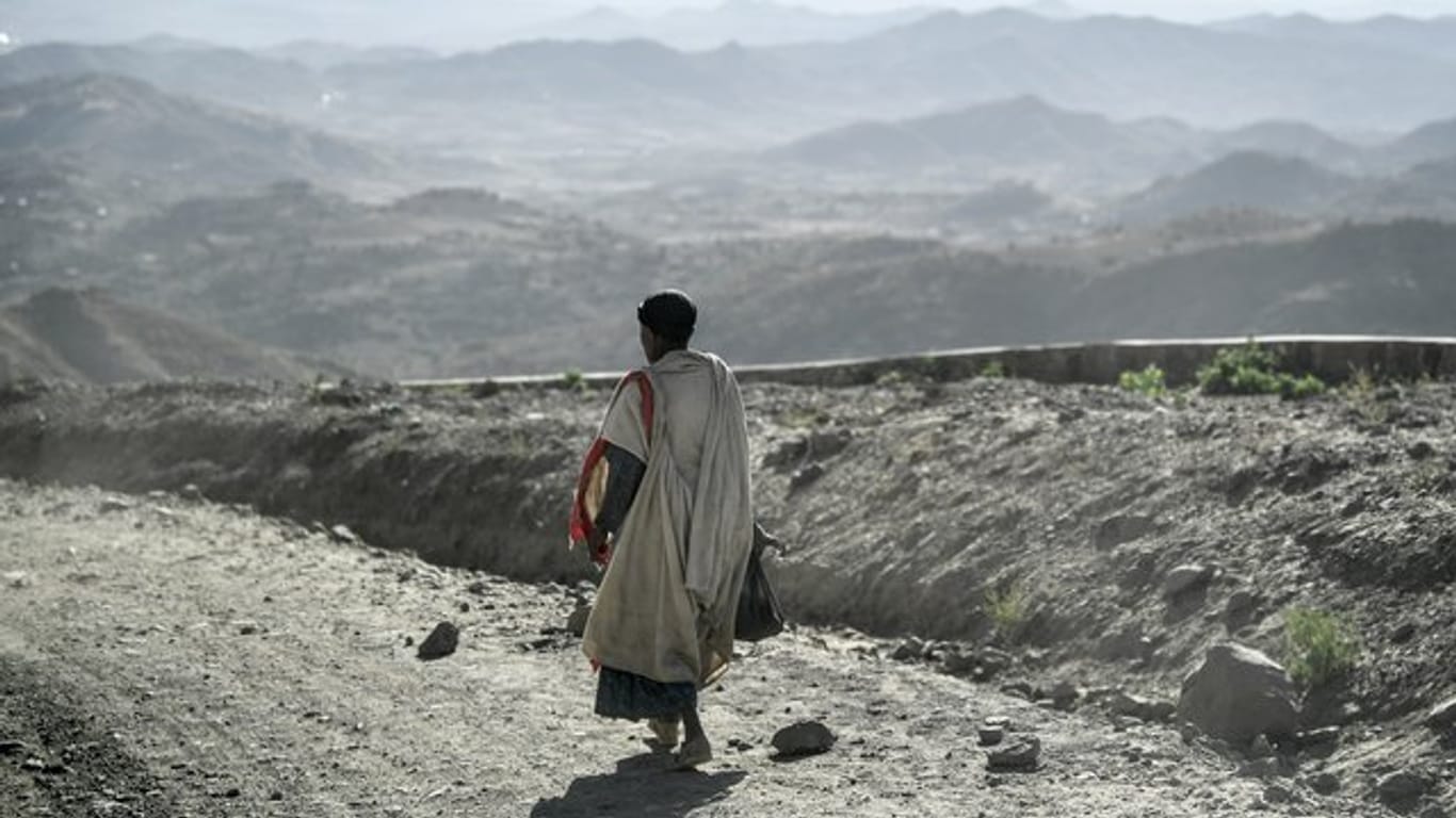 Ein Mann geht entlang einer staubigen Landstraße in Äthiopien.