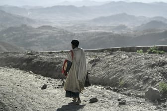 Ein Mann geht entlang einer staubigen Landstraße in Äthiopien.