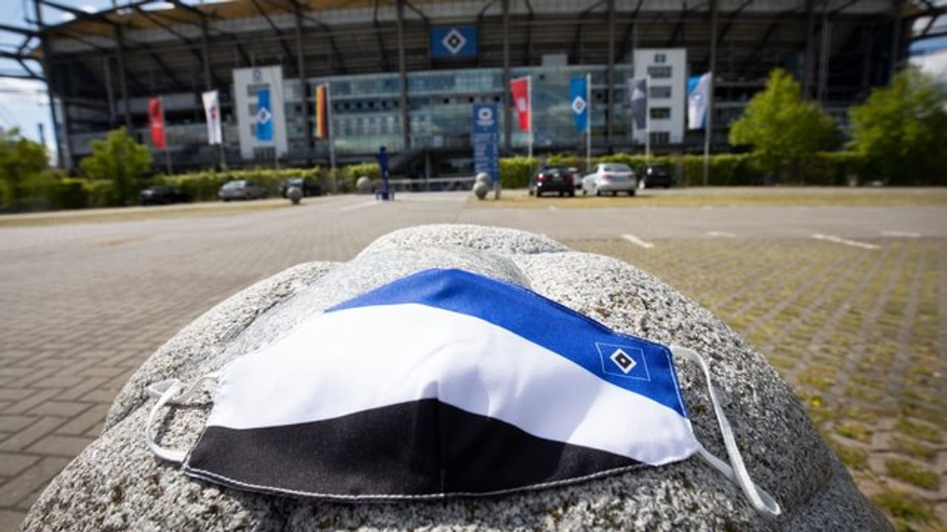 Ein Mundschutz in den Farben des HSV liegt vor dem Volkspark Stadion: Die Masken sind bei Fans begehrt.