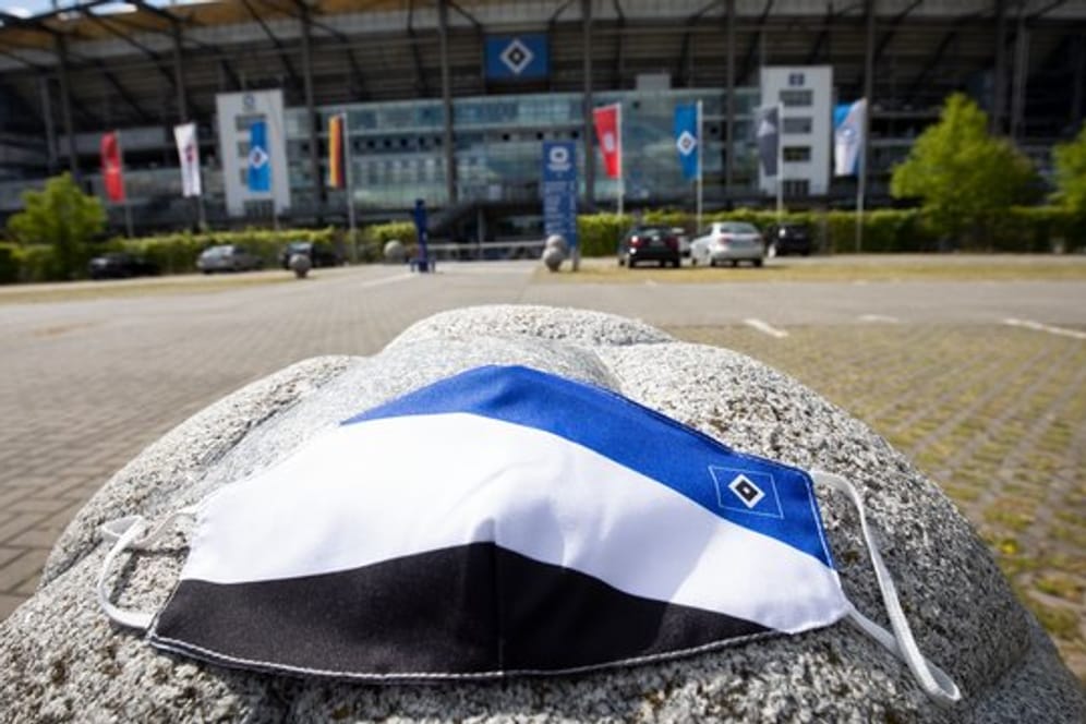 Ein Mundschutz in den Farben des HSV liegt vor dem Volkspark Stadion: Die Masken sind bei Fans begehrt.