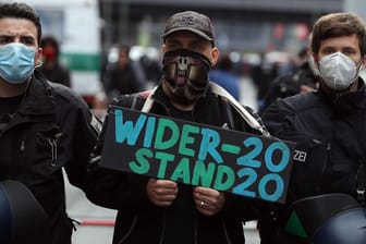 "Widerstand 2020": Ein Teilnehmer mit einem Plakat für die Partei am 1. Mai am Rande einer Demonstration gegen die Kontaktbeschränkungen in der Coronakrise.