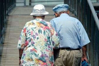 Ein altes Ehepaar geht Arm in Arm zusammen spazieren: Die Grundrente soll die Rente von Geringverdienern aufstocken.
