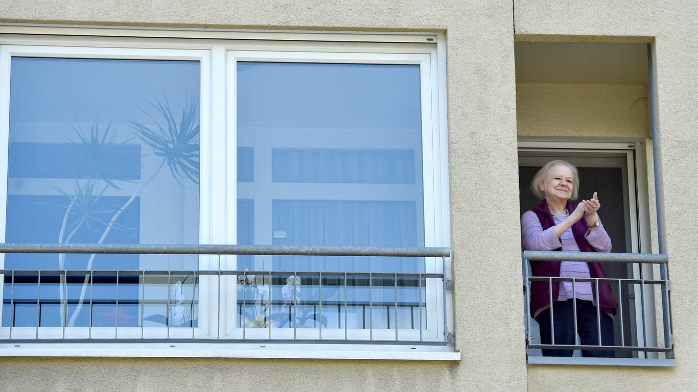 Eine Bewohnerin steht am Fenster und klatscht: Das Konzertformat "Musik auf Rädern" soll nun regelmäßig stattfinden.