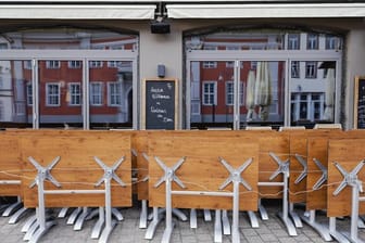 Hochgeklappte Tische stehen in der Fußgängerzone von Speyer vor einer Gastwirtschaft (Symbol).