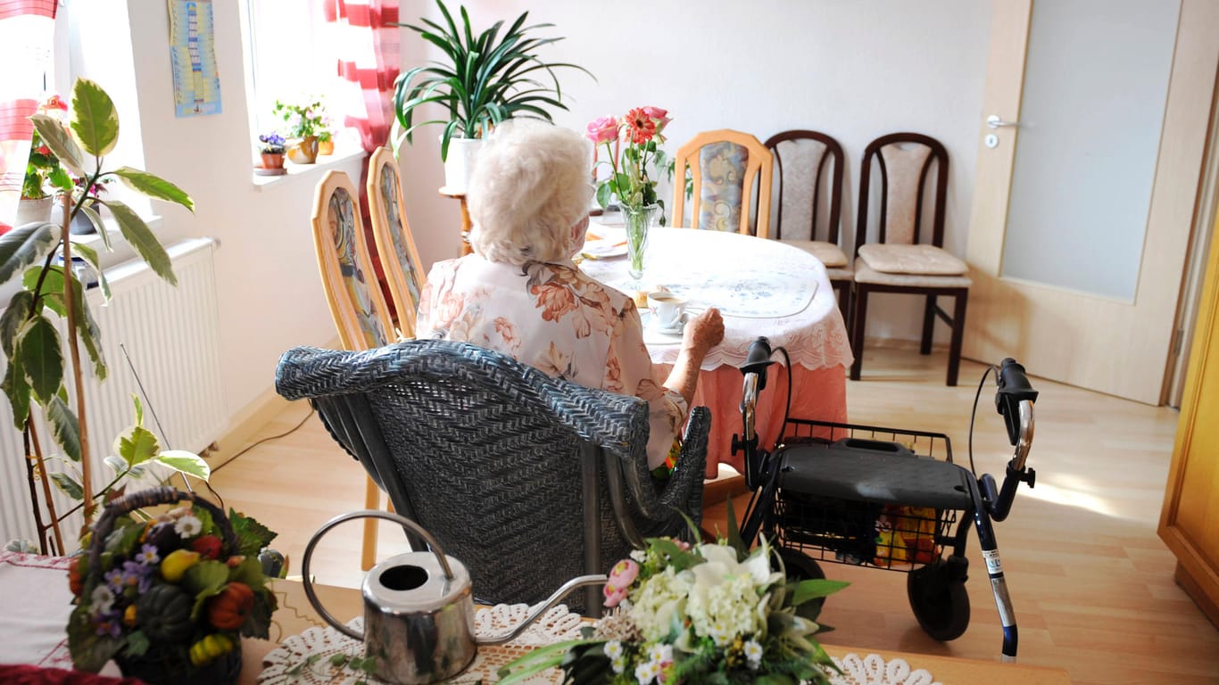 Eine ältere Dame sitzt an einem leeren Tisch: Bewohner in Alten- und Pflegeheimen in Rheinland-Pfalz dürfen wieder Besucher empfangen.