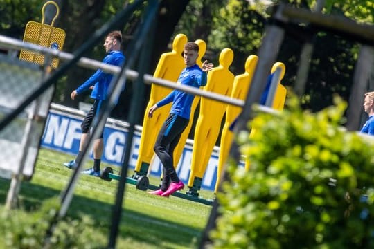 Krzysztof Piatek (M) betritt mit anderen Hertha-Profis den Übungsplatz.