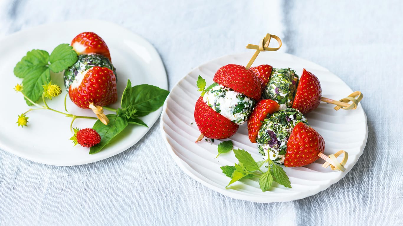 Fruchtige Spieße: Dazu steckt man Frischkäsebällchen zwischen Erdbeerhälften auf Zahnstocher.