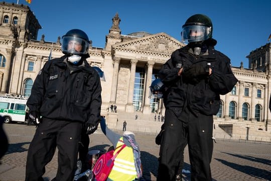 Polizeibeamte eine Demonstration vor dem Reichstagsgebäude in Berlin auf.
