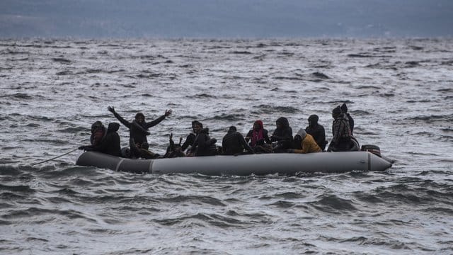 Vor der Küste Griechenlands winken Menschen in einem Schlauchboot um Hilfe. Vor der Küste Griechenlands winken Menschen in einem Schlauchboot um Hilfe.