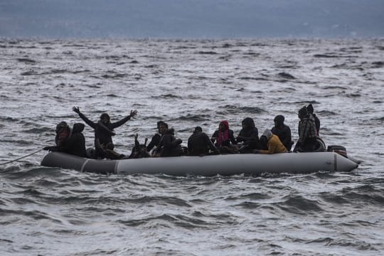Vor der Küste Griechenlands winken Menschen in einem Schlauchboot um Hilfe.