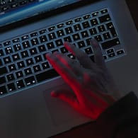 Eine Hand an einer Tastatur (Symbolbild): Nutzerdaten einer Pornoplattform waren öffentlich einsehbar.