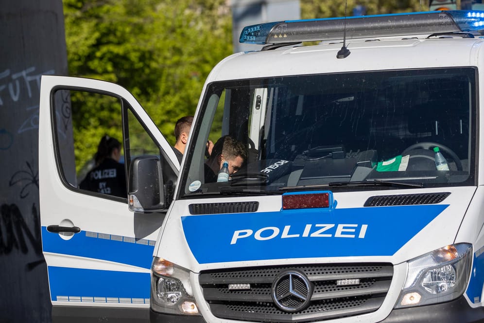 Beamte der Polizei stehen an einem Einsatzwagen (Symbolbild): In Hannover wurden zwei Personen festgenommen.