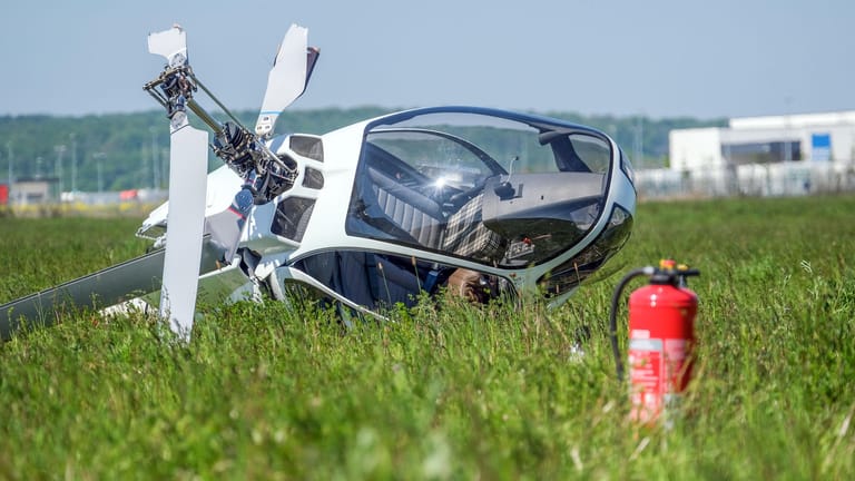 Ein Hubschrauber liegt nach einem Absturz auf einer Wiese: Zwei Männer sind dabei leicht verletzt worden.