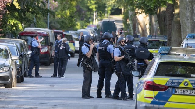 Schwer bewaffnete Polizisten sichern nach der Schießerei ein Wohngebiet in Darmstadt-Kranichstein. Schwer bewaffnete Polizisten sichern nach der Schießerei ein Wohngebiet in Darmstadt-Kranichstein.