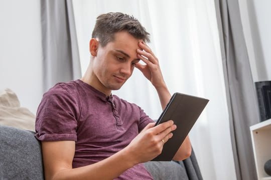 Ein Mann am Tablet: Wer sich bei betrügerischen Pseudo-Streamingdiensten anmeldet, kann die versprochenen Filme nicht sehen – und erhält dann noch Mahnungen.