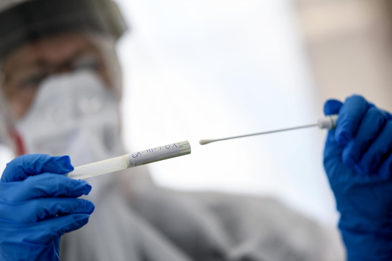 Eine Mitarbeiterin hält ein Abstrichstäbchen eines Coronavirus-Tests: "Uns ist schleierhaft, wo sie herkommt", sagt die BVÖGD-Vorsitzende über die Zahl 50, bei der die Obergrenze liegt. (Symbolbild)