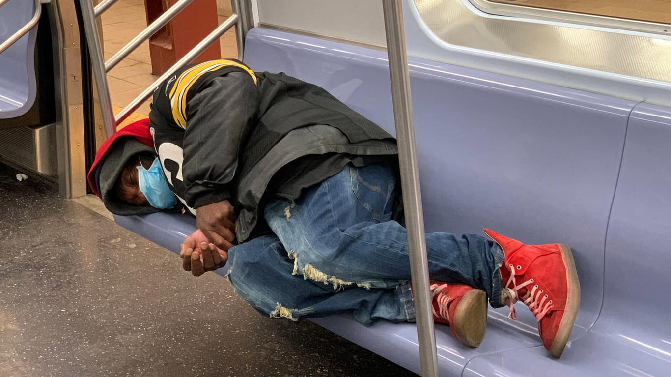 Ein Mann liegt in der New Yorker U-Bahn: Durch die Corona-Krise steigt die Arbeitslosigkeit in den USA massiv.