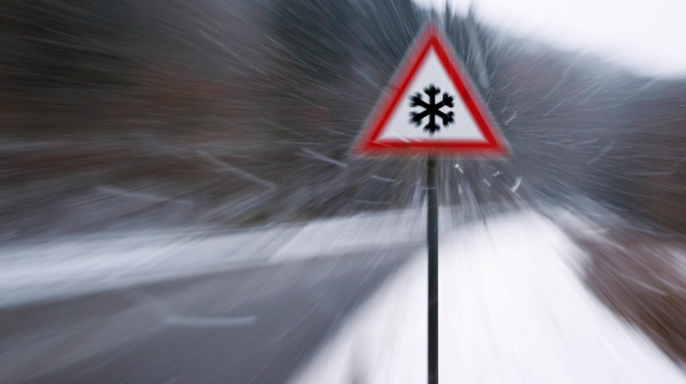 Verkehrsschild mit Eiswarnung bei Schneefall (Symbolbild): Ab kommender Woche kühlt sich das Wetter in Deutschland erheblich ab.