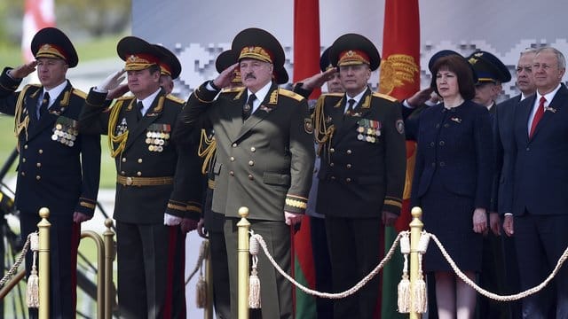 Der weißrussische Präsident Alexander Lukaschenko (M) salutiert, während er die Militärparade in Minsk verfolgt. Der weißrussische Präsident Alexander Lukaschenko (M) salutiert, während er die Militärparade in Minsk verfolgt.
