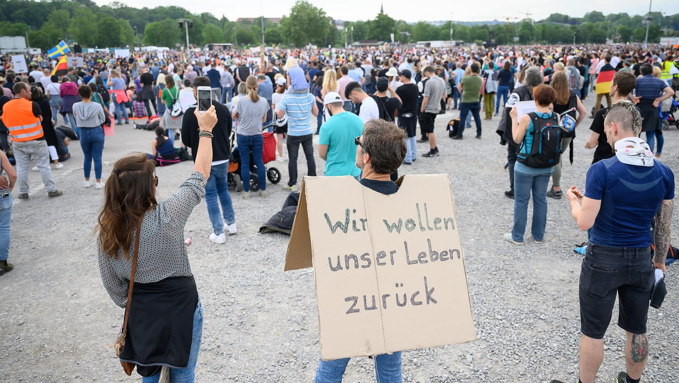 Stuttgart: Ein Mann steht während einer Protestkundgebung der Initiative "Querdenken 711" mit einem Schild auf dem Cannstatter Wasen.