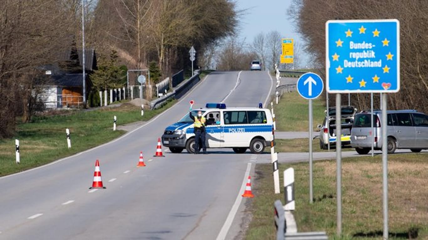 Polizisten stehen an der Bundesstraße 512 in der Nähe von Neuhaus am Inn an einer Kontrollstelle an der Grenze zu Österreich.