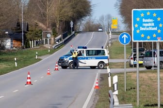 Polizisten stehen an der Bundesstraße 512 in der Nähe von Neuhaus am Inn an einer Kontrollstelle an der Grenze zu Österreich.