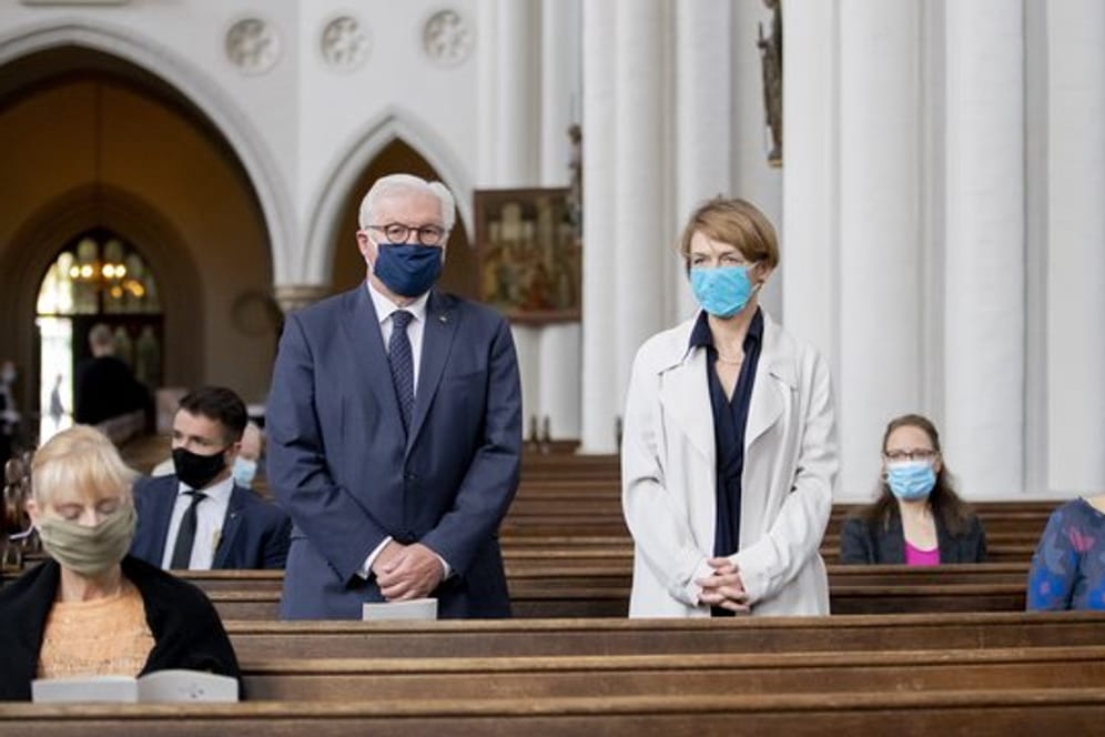Bundespräsident Frank-Walter Steinmeier und seine Frau Elke Büdenbender stehen mit Mund-Nasen-Schutz in der evangelischen St.