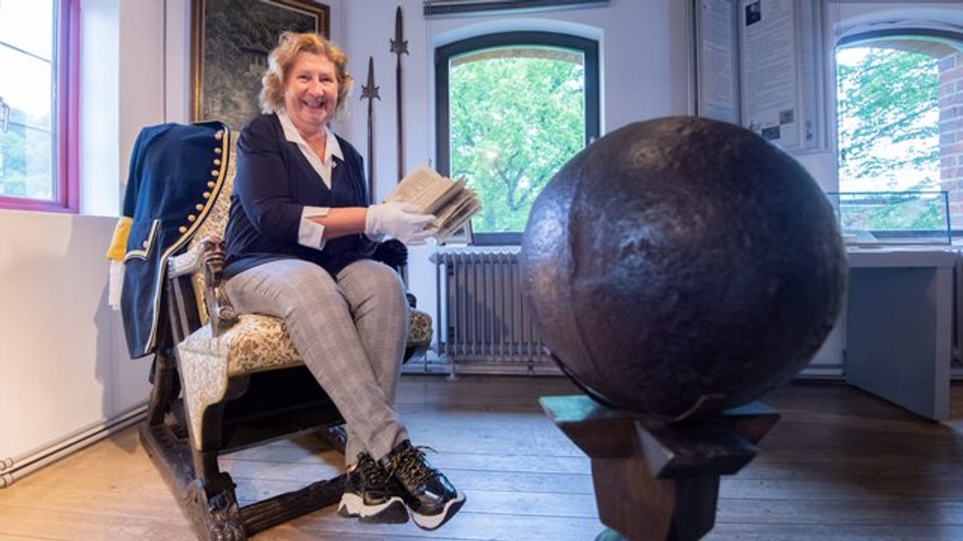 Museumsdirektorin Claudia Erler mit einem historischen Buch im Münchausen-Museum Bodenwerder.