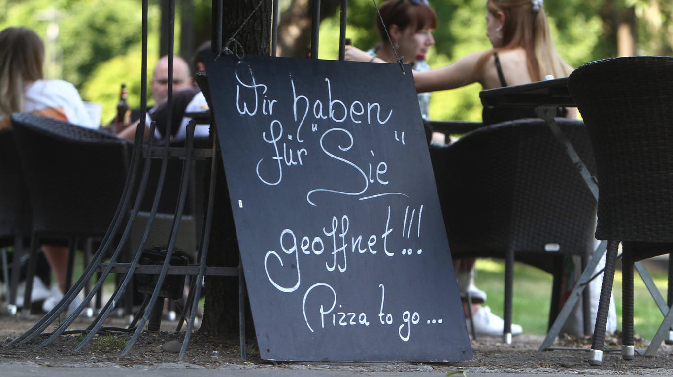 Ein Schild weist auf ein geöffnetes Lokal hin (Symbolbild): In Wuppertal machen einige Einrichtungen und die Gastronomie nach der Corona-Pause wieder auf.