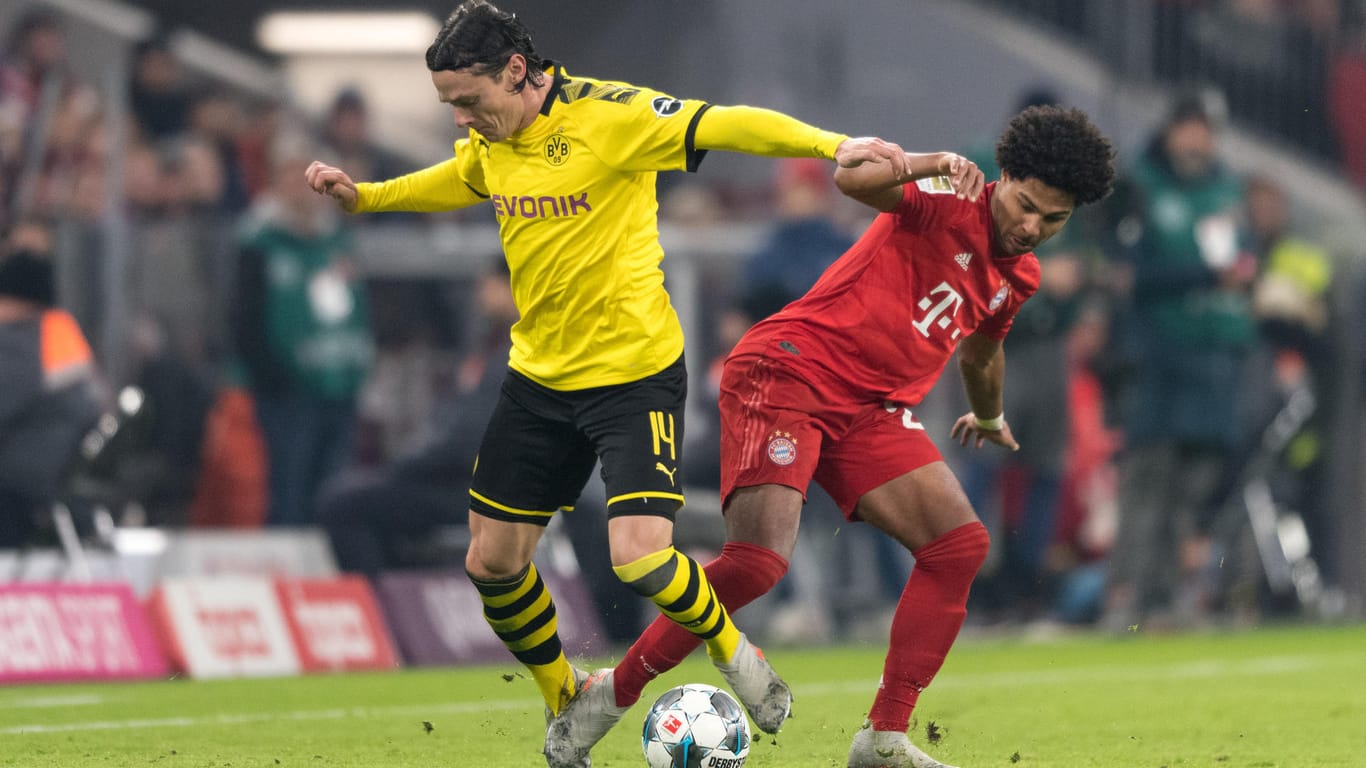Nico Schulz vom BVB im Duell mit Bayerns Serge Gnabry. Dieses Duell könnte es bald wieder in der Bundesliga geben. Mediziner warnen allerdings vor schweren Folgeschäden, sollten sich Spieler infizieren.
