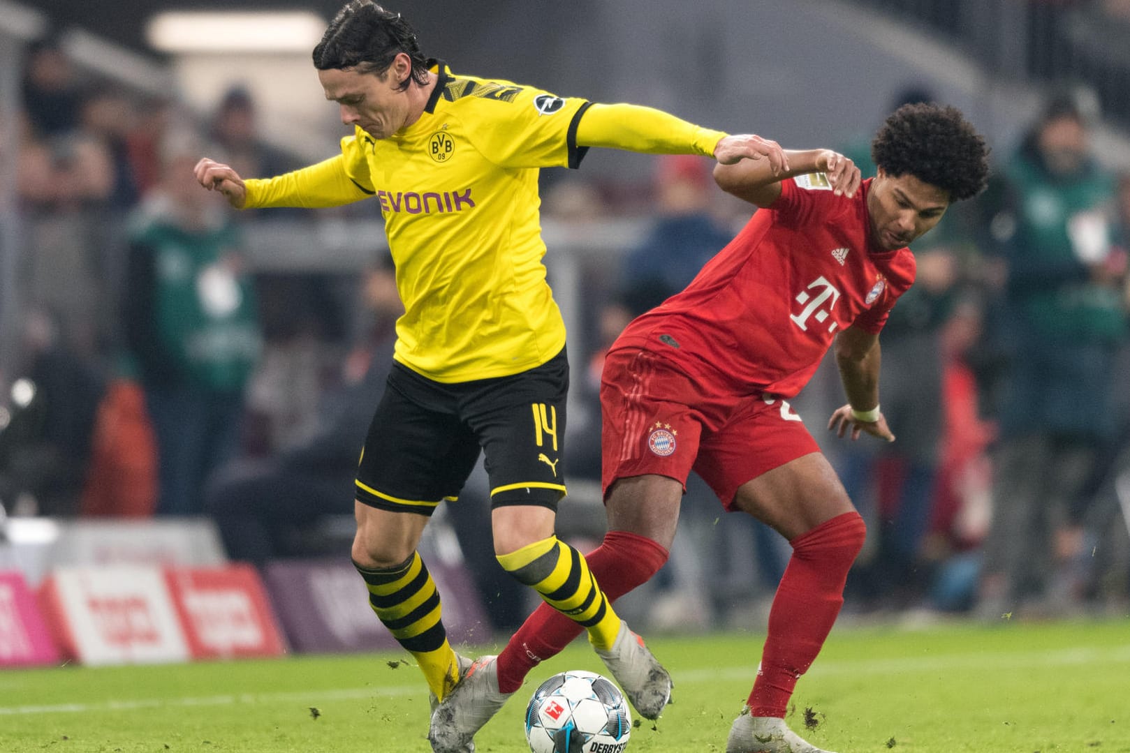 Nico Schulz vom BVB im Duell mit Bayerns Serge Gnabry. Dieses Duell könnte es bald wieder in der Bundesliga geben. Mediziner warnen allerdings vor schweren Folgeschäden, sollten sich Spieler infizieren.